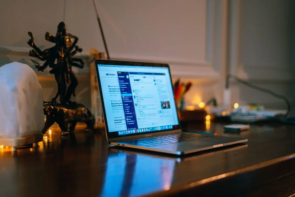 Two businessmen analyze stock market data using a smartphone and laptop in a modern office setting.